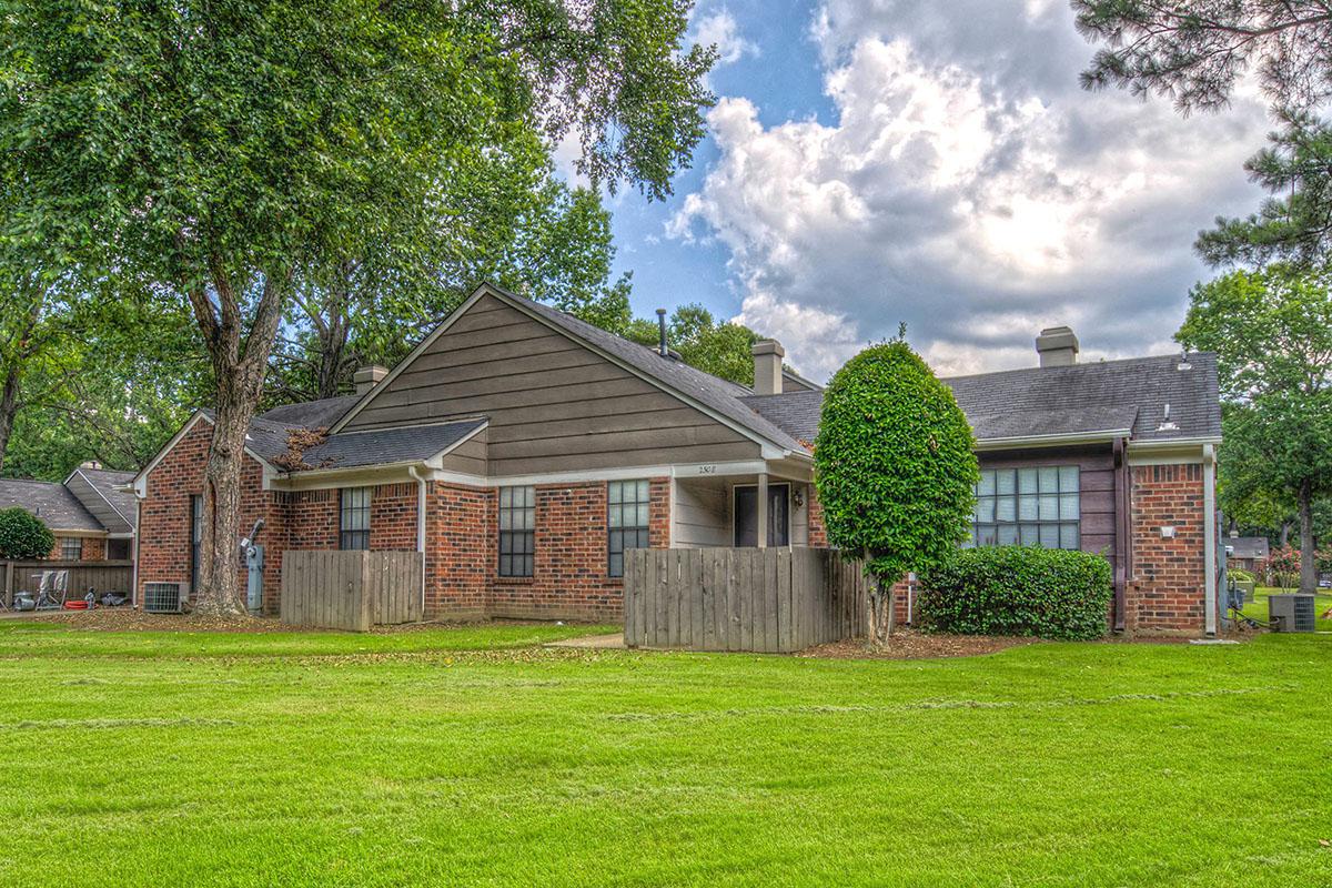Brick building with lush green yard.