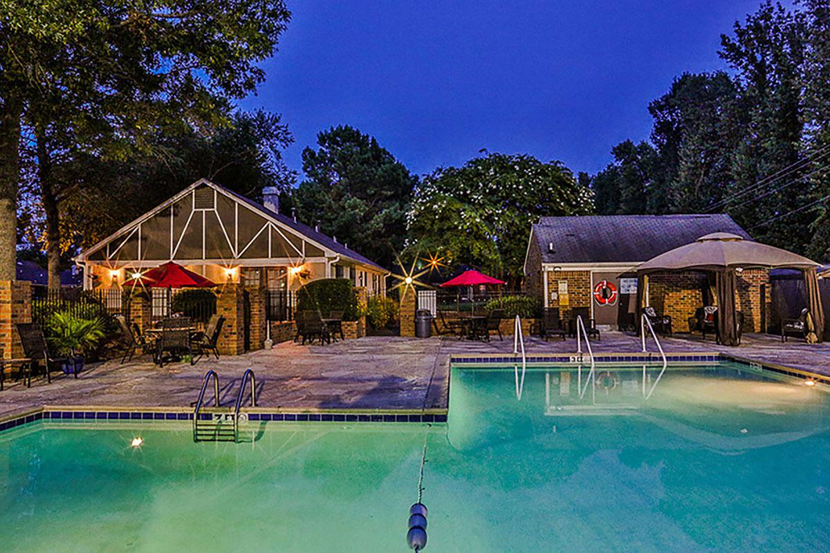Pool area illuminated at night with outdoor lighting.