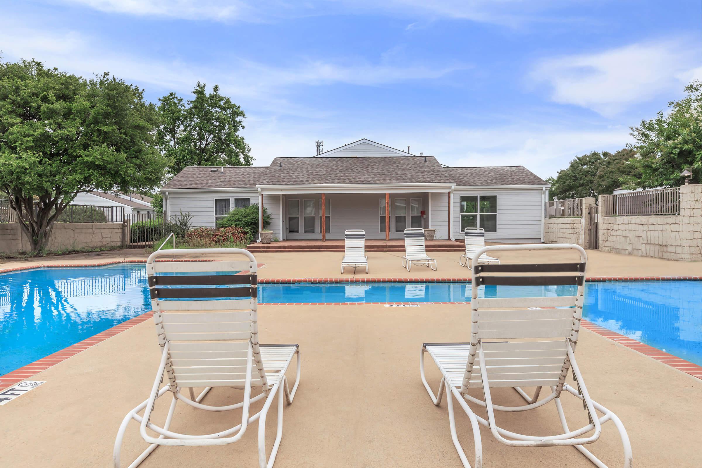 Poolside chairs with view of the water.
