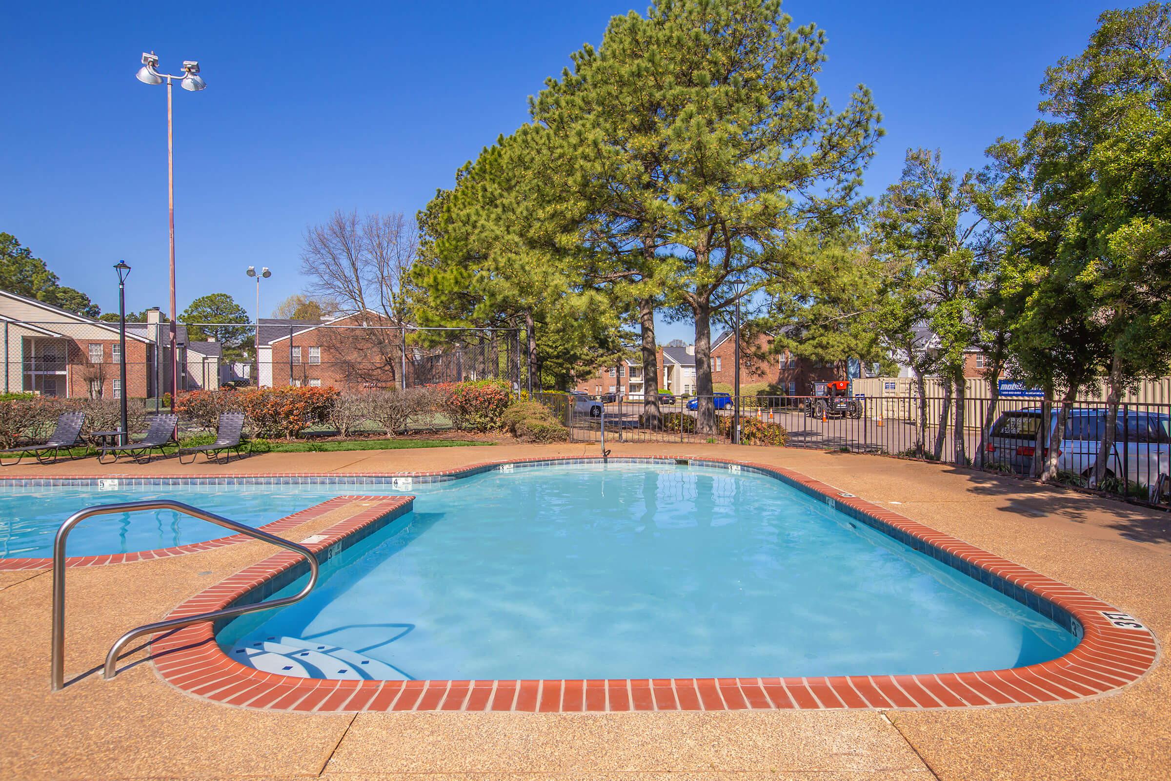 Pool with built-in steps surrounded by a landscaped area.