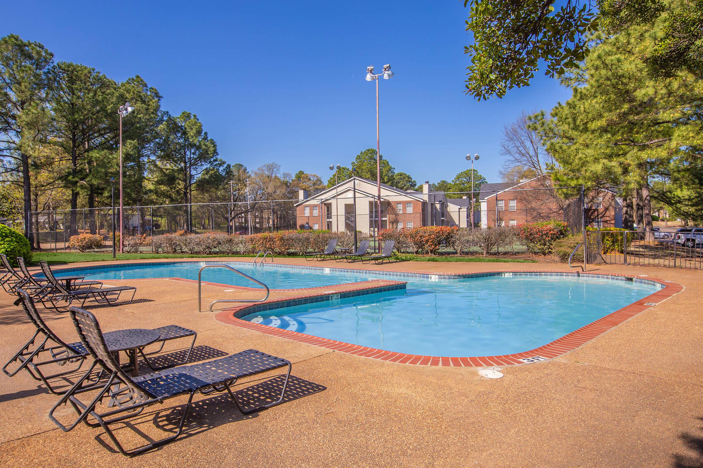Smaller outdoor pool with seating area and landscaping.