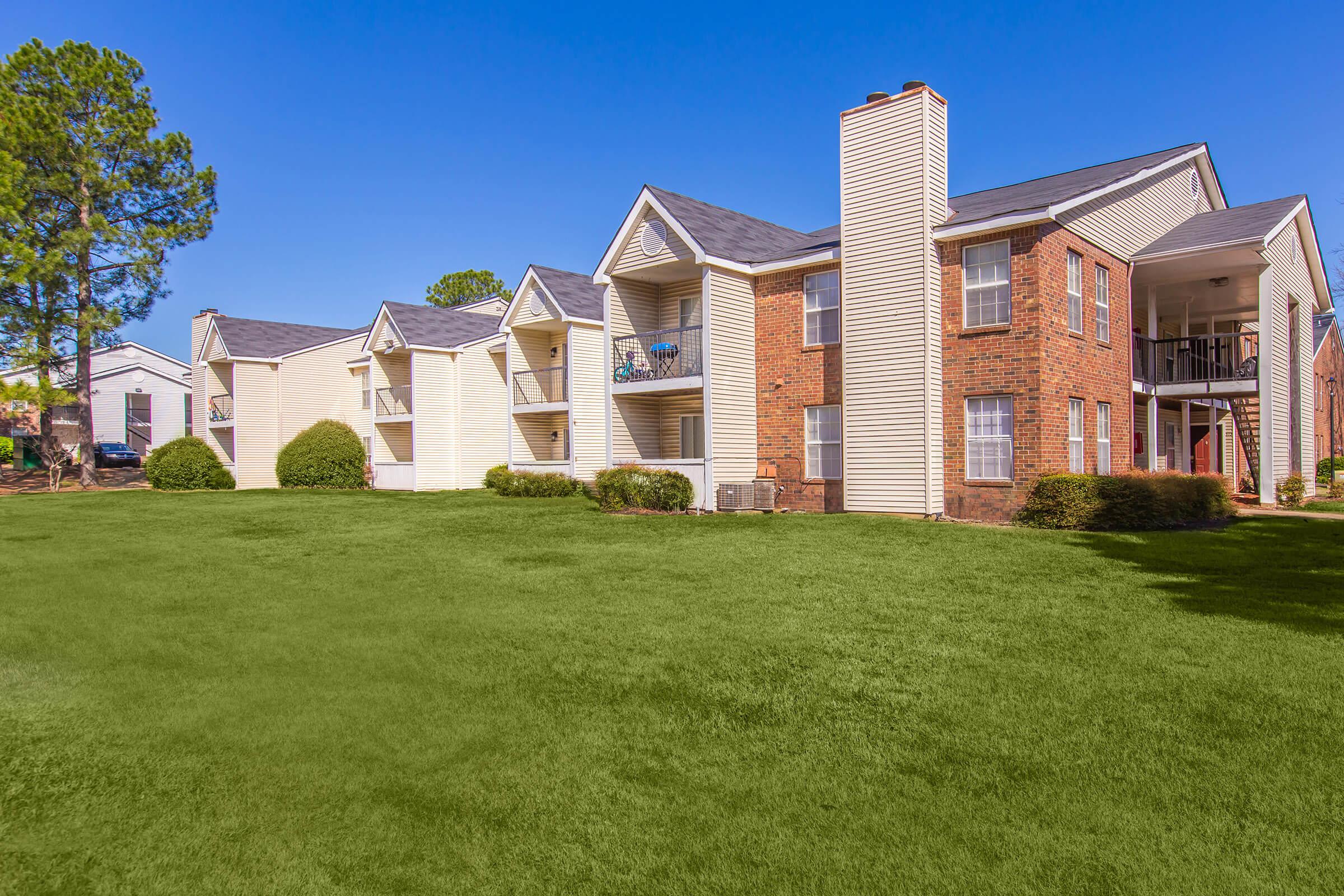 Apartments with brick exteriors and well-maintained lawns.