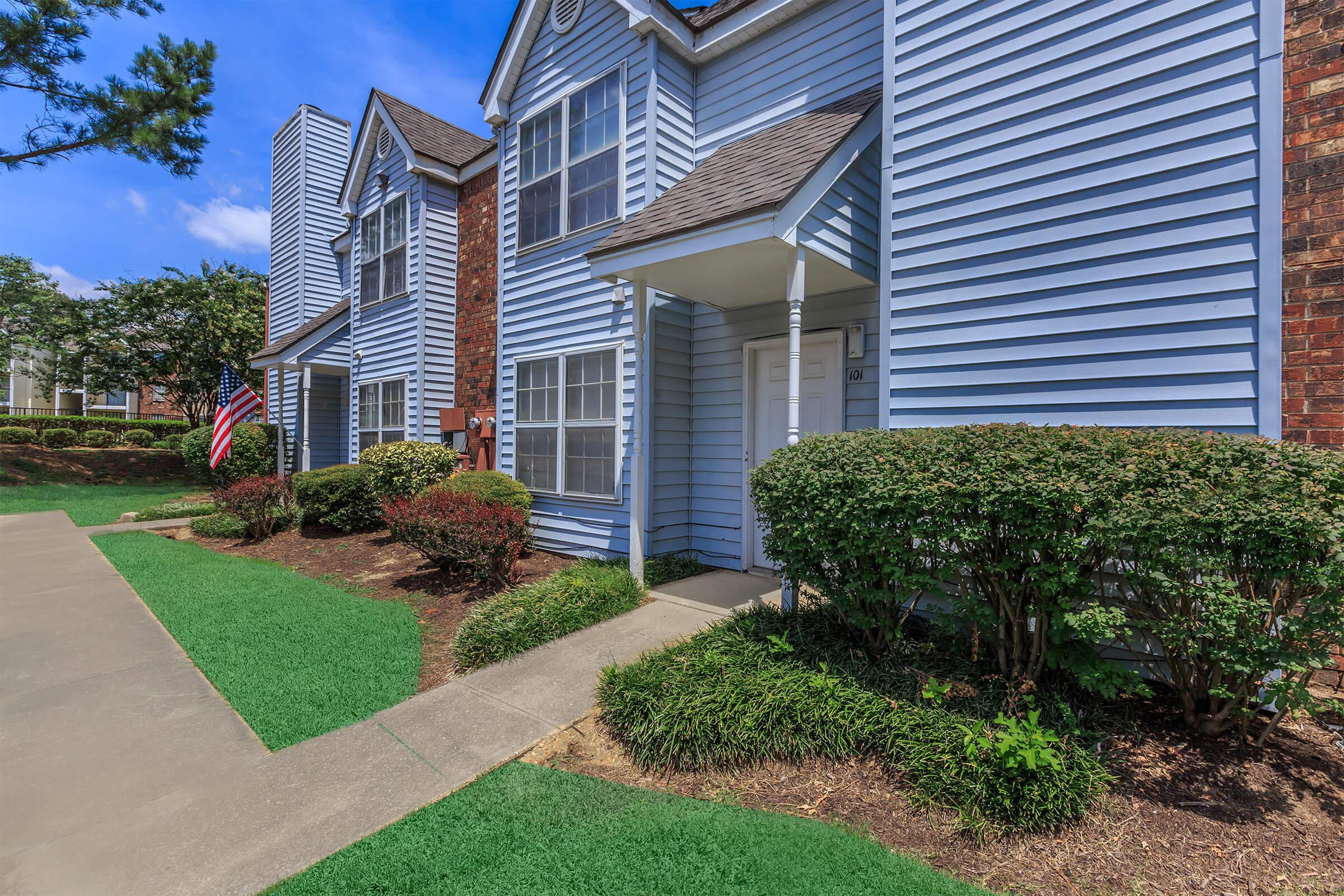 Open grassy areas in front of multi-story apartments.