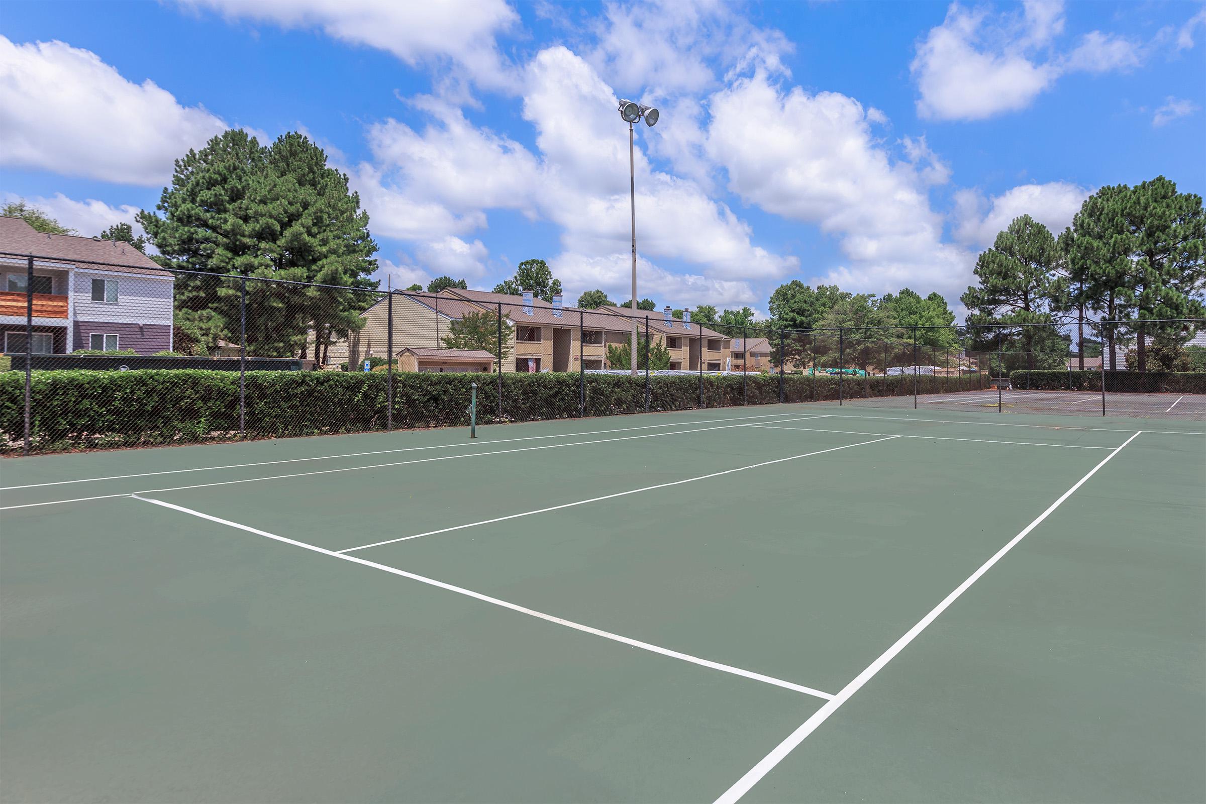 Tennis court with surrounding trees.