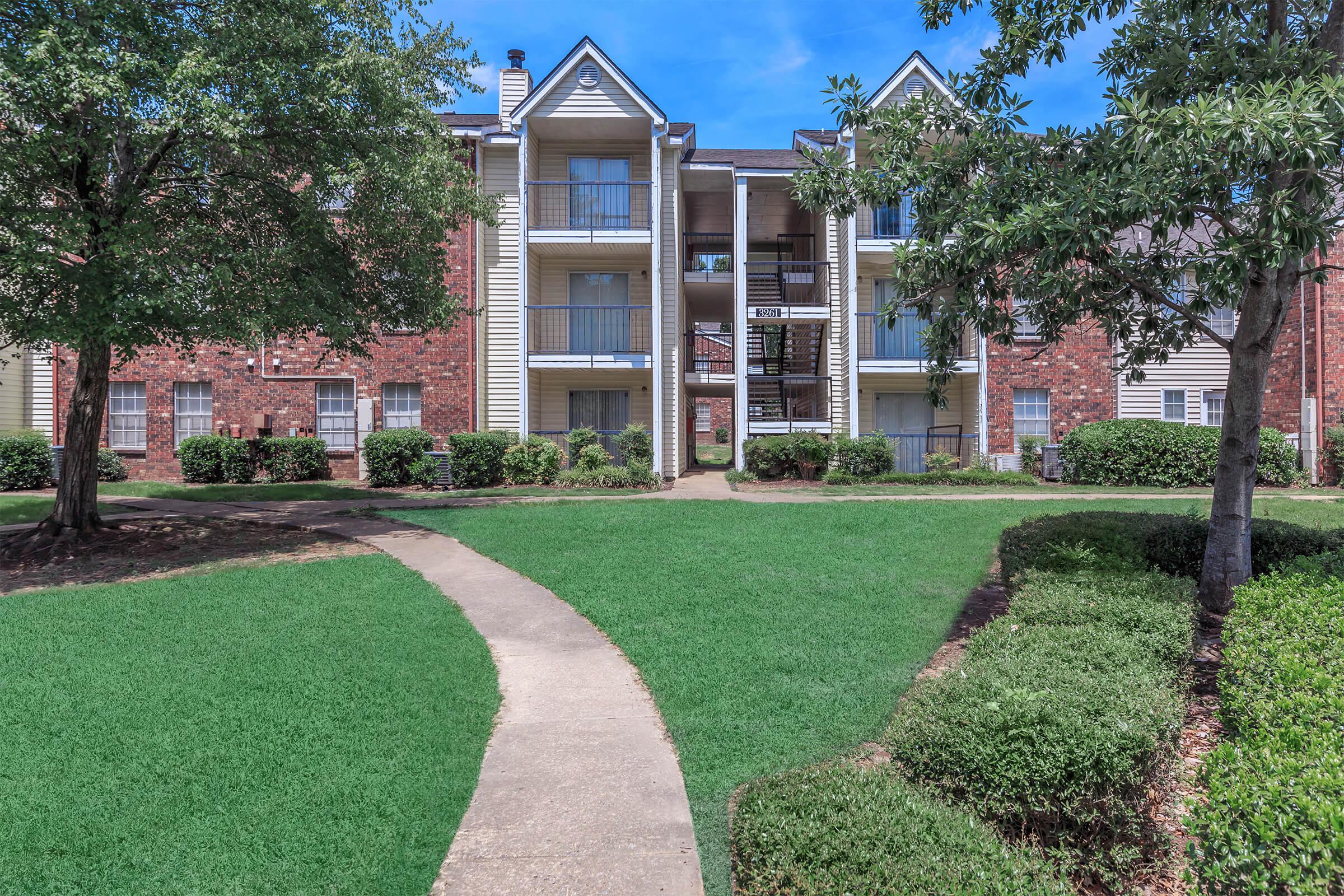 Apartment buildings with brick exteriors and open lawns.