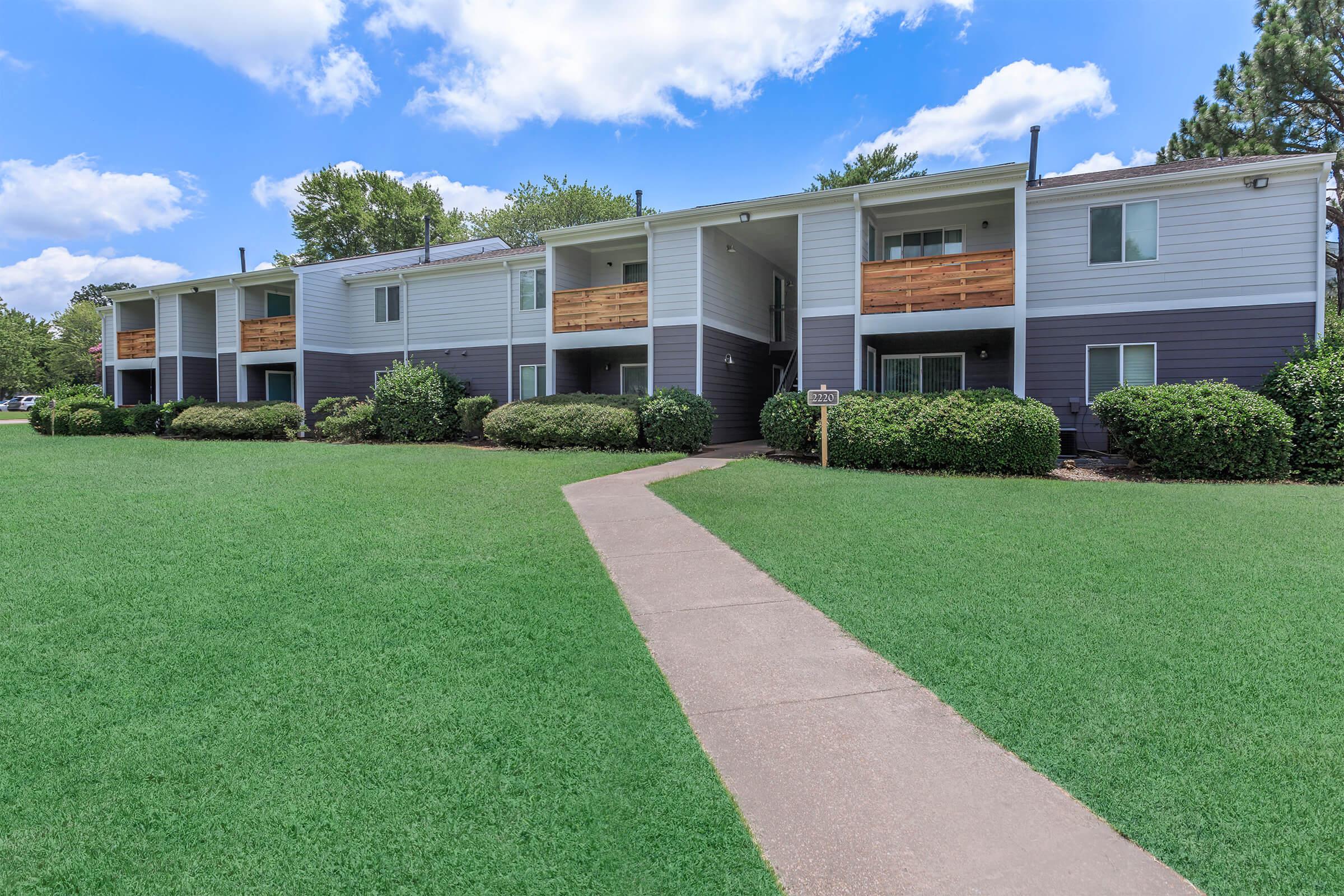 Apartment buildings with grassy lawn.