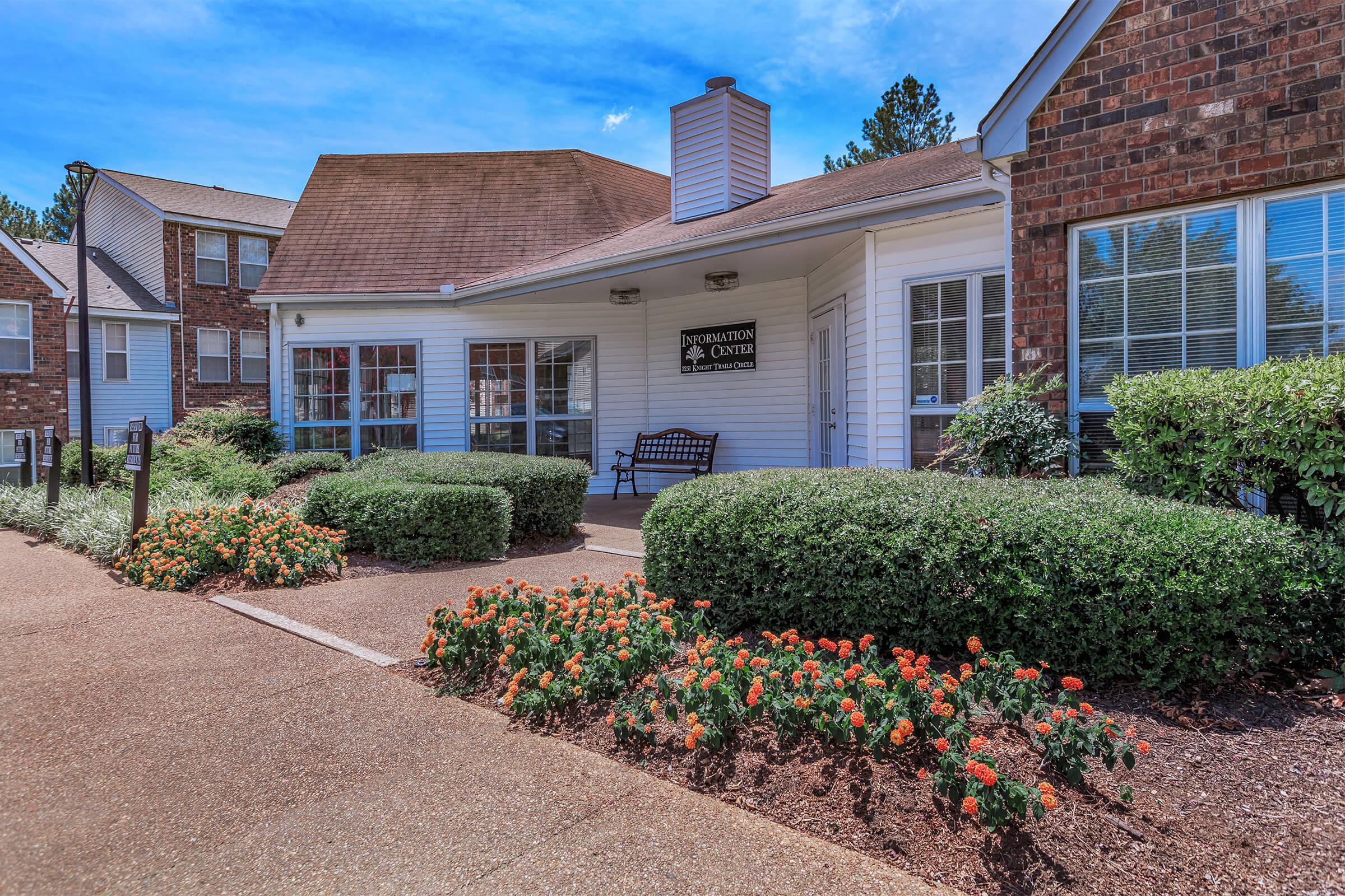 Clubhouse entrance with flowers and shrubs.