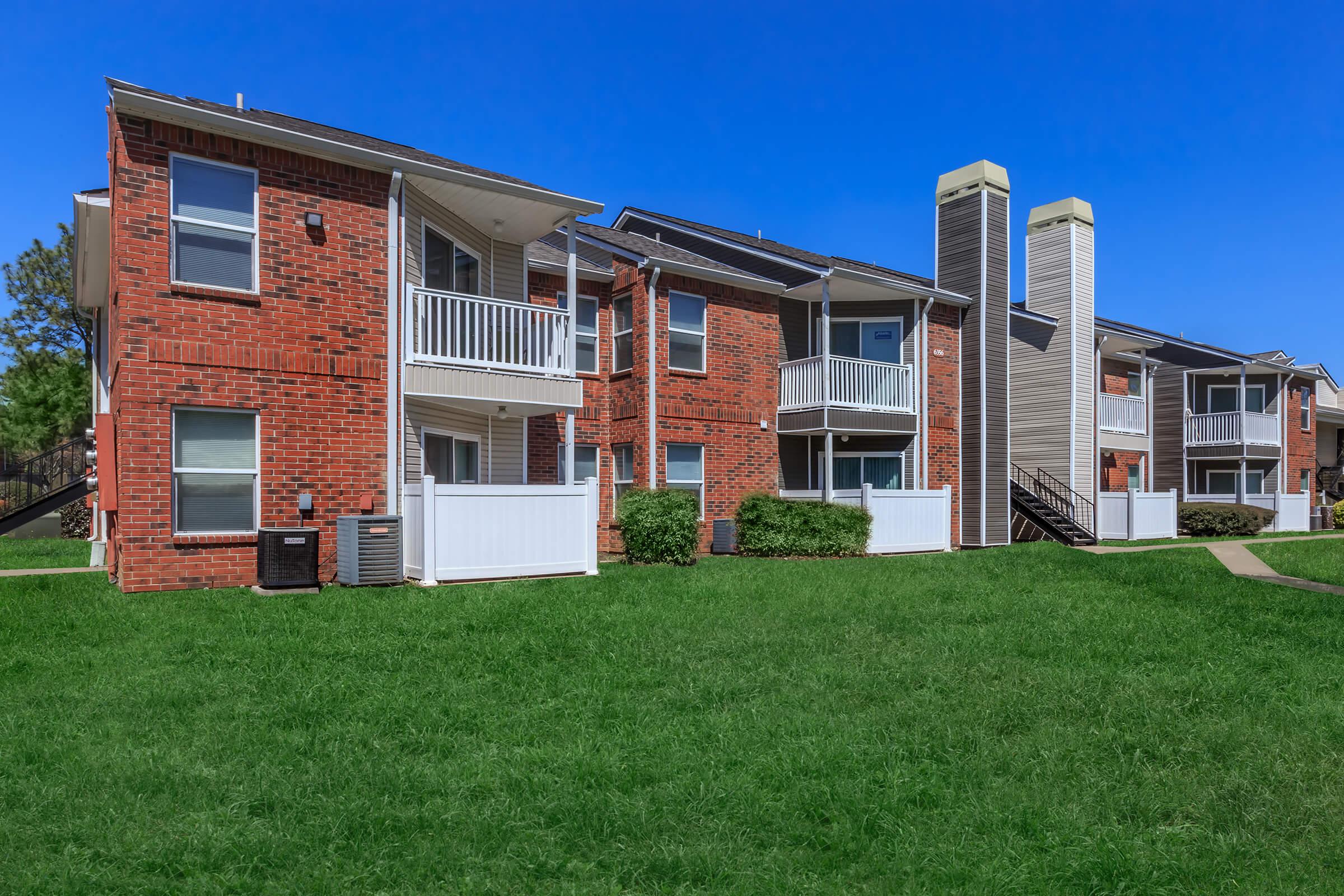 Apartment building with shrubs and pathway.