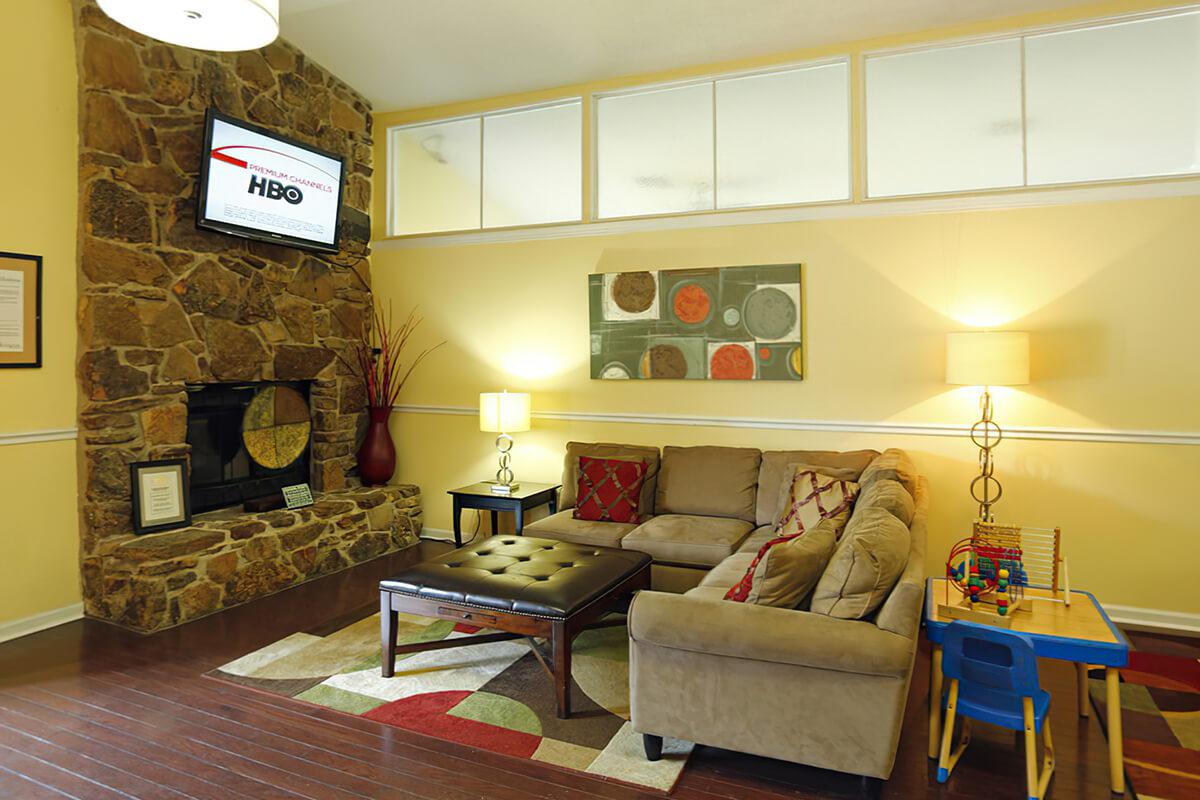Cozy lounge area with a couch and stone fireplace.