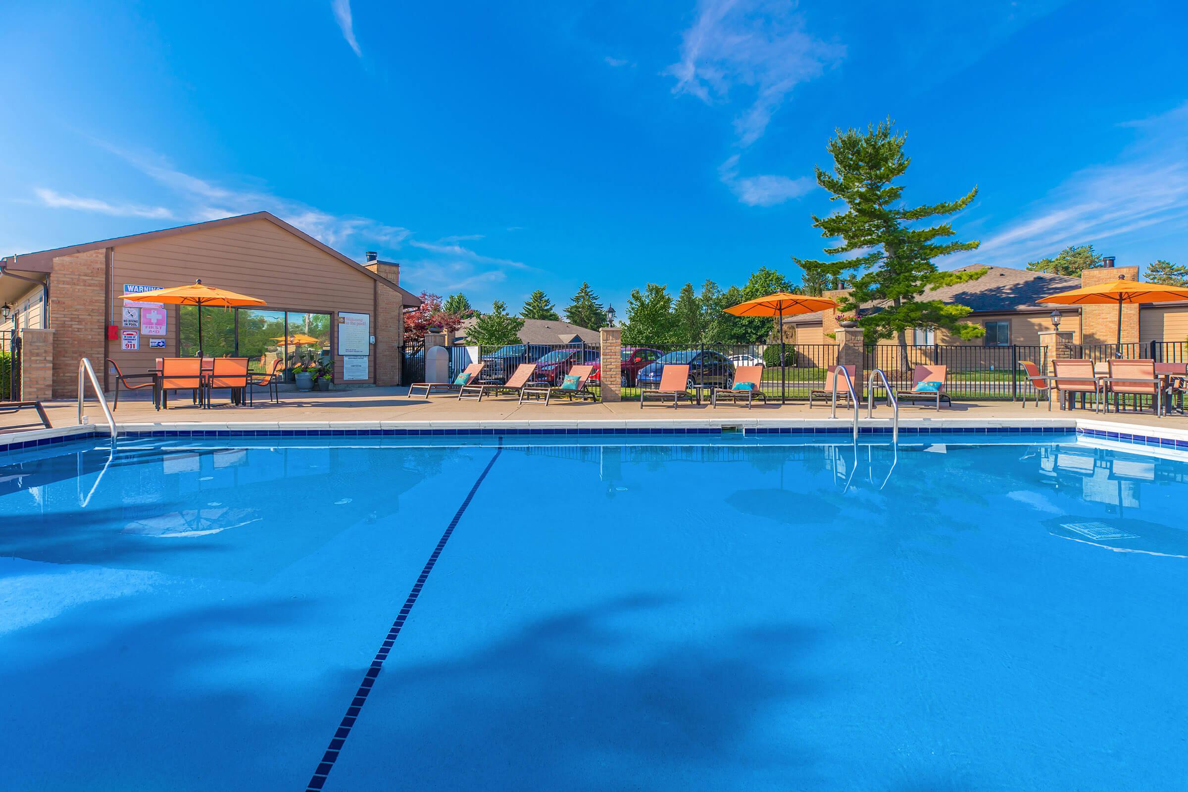 Pool view with buildings and trees in the background.