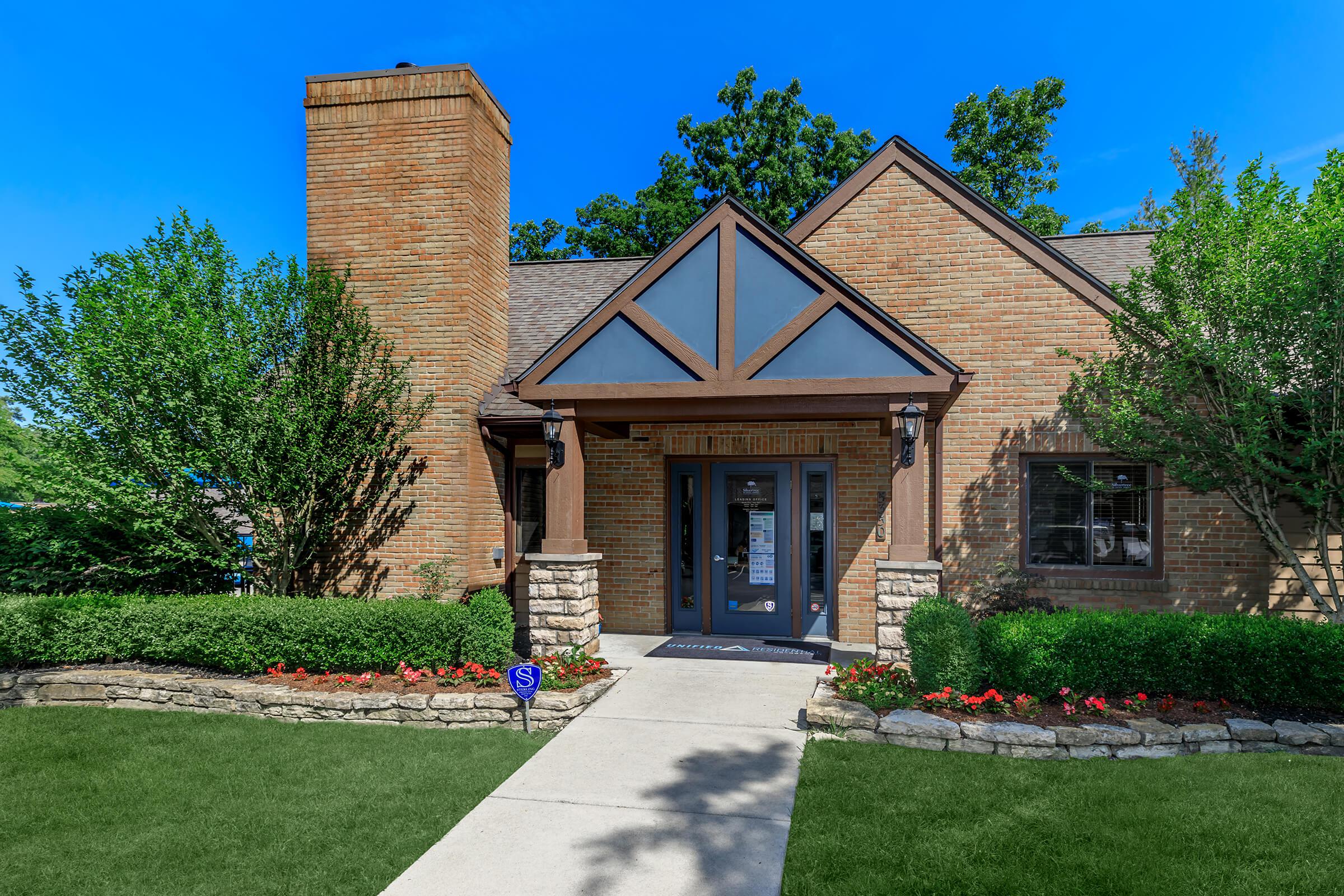 Building exterior with brown brick and green landscaping.