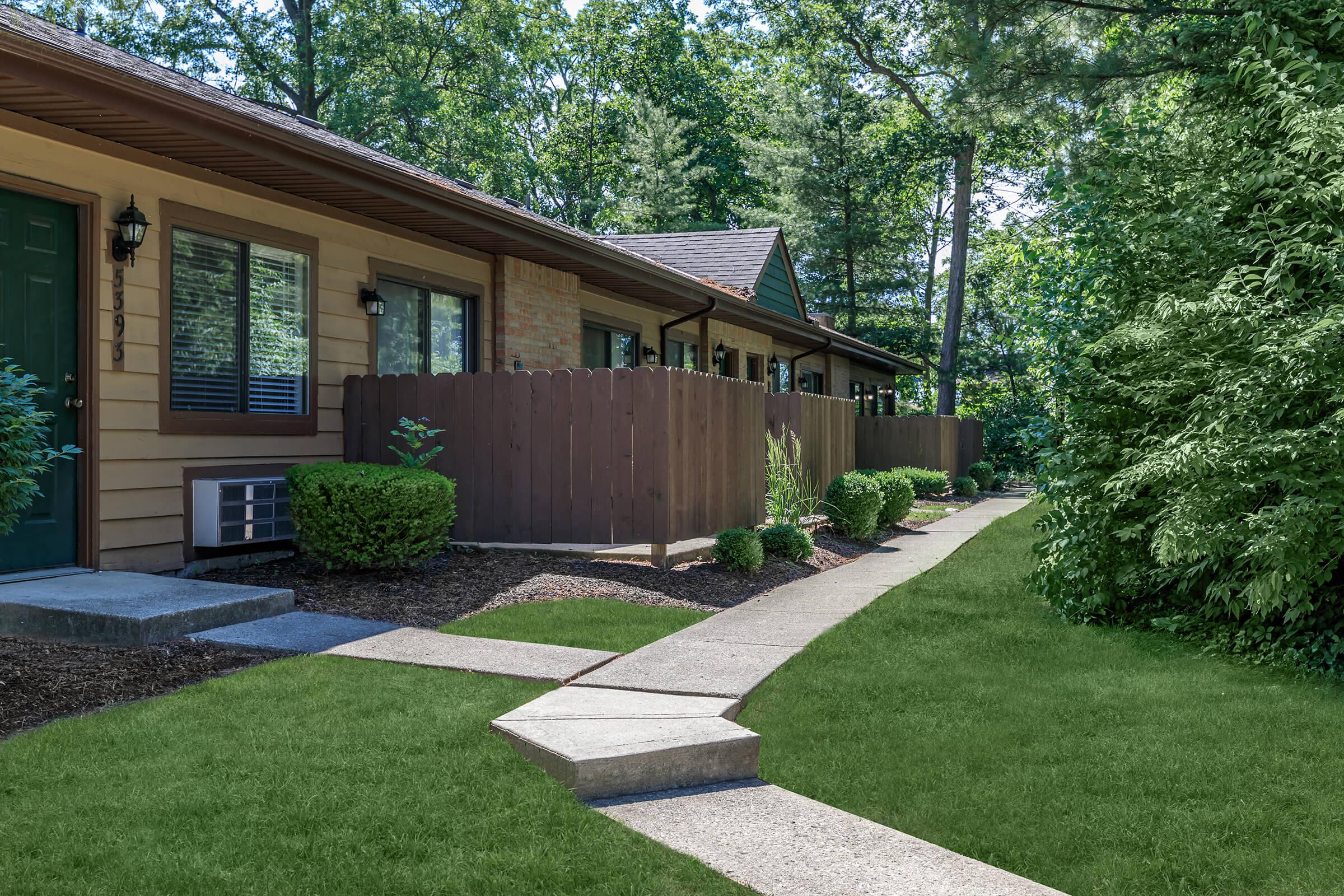 Building exterior with several doors and surrounding fence.