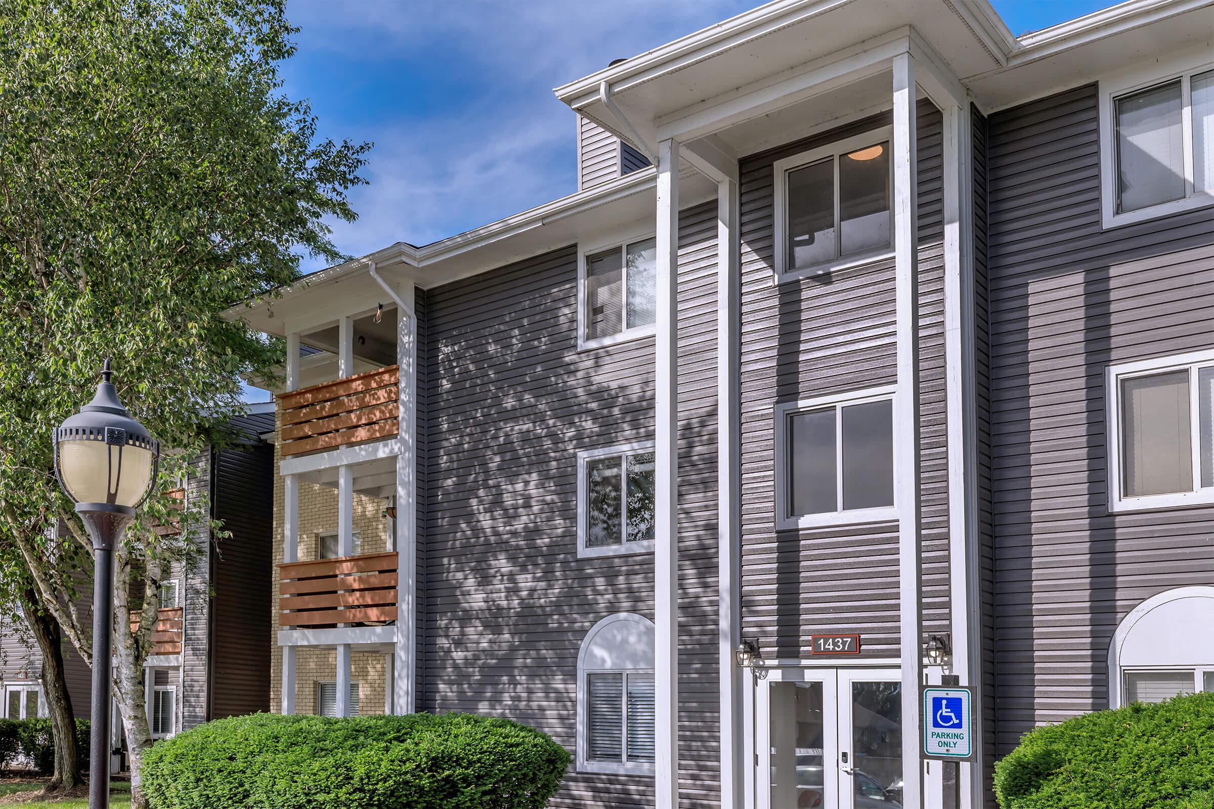Apartment building with lawn and outdoor seating.