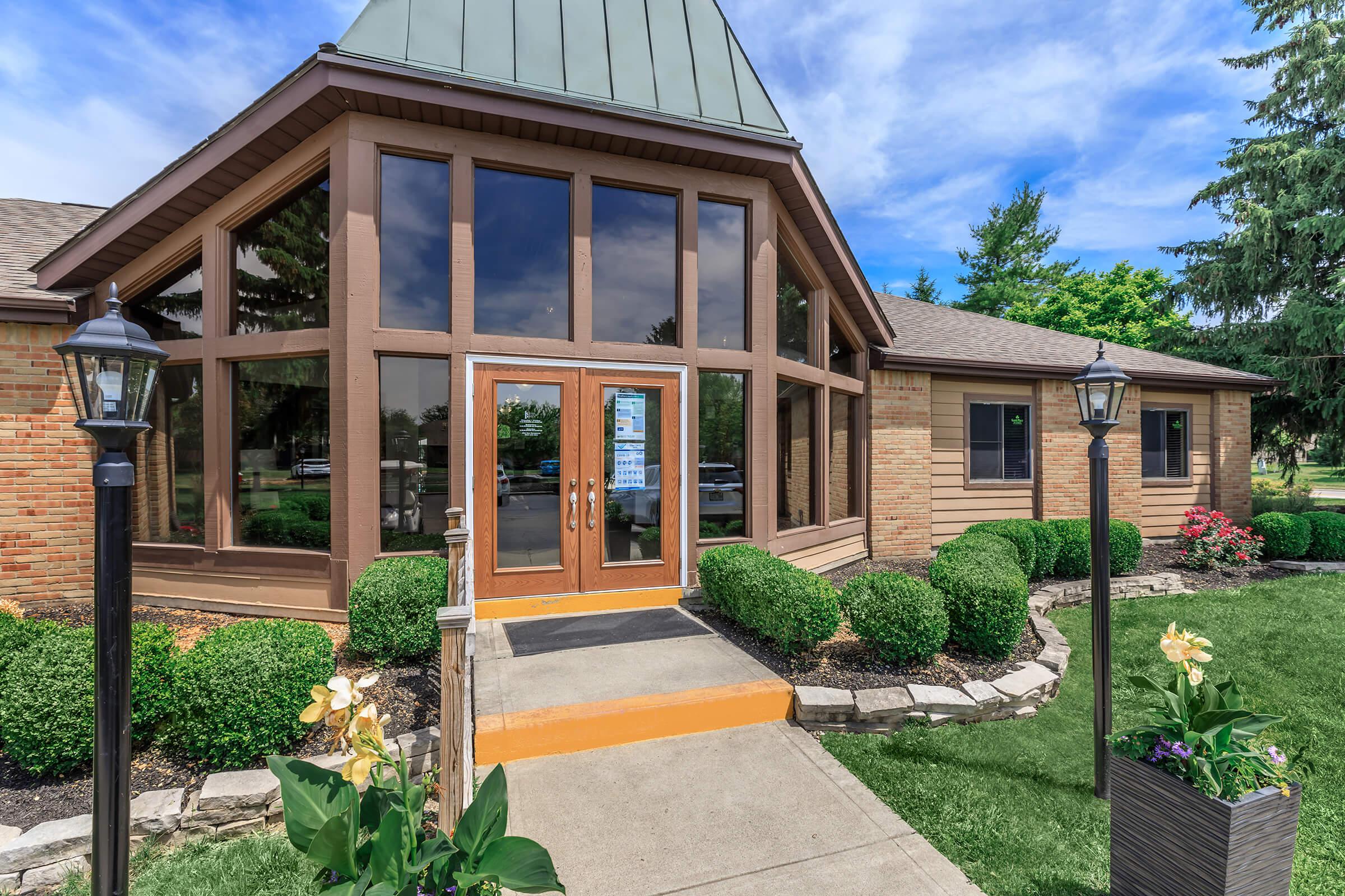 Building exterior with large windows and green landscaping.