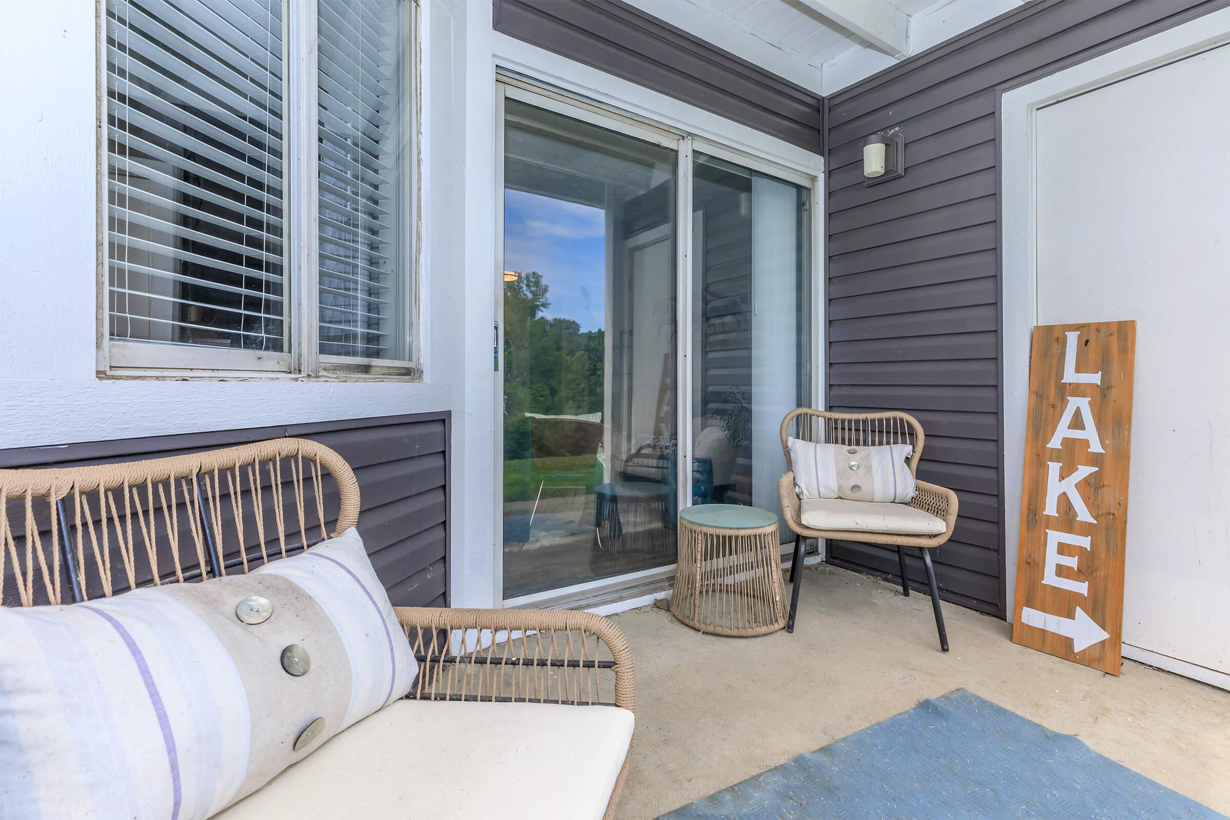 Balcony seating area with a view of a lake.