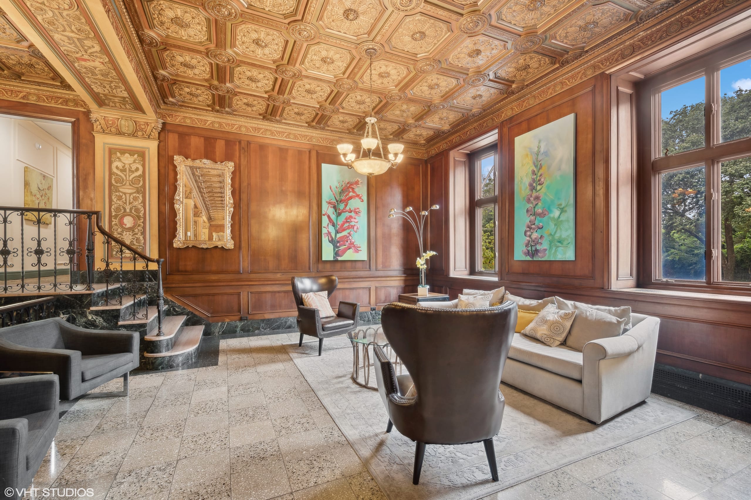 Stylish sitting area with armchairs and a staircase in a luxurious room.