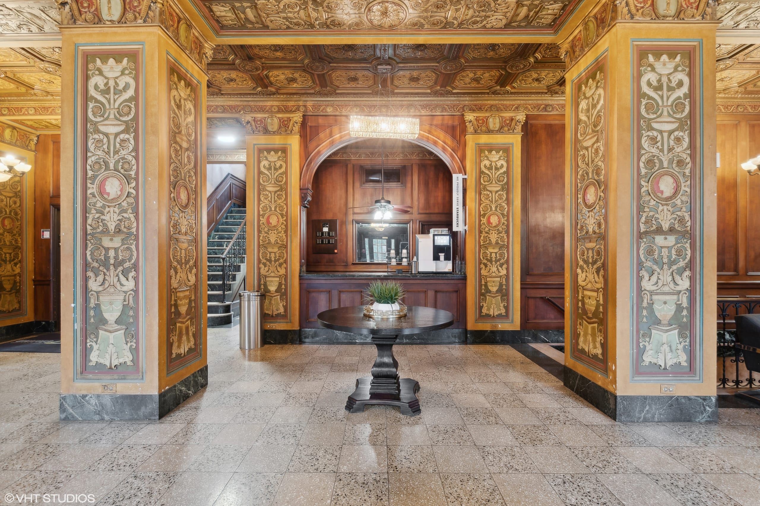 Grand hallway with golden decorative columns and intricate designs.