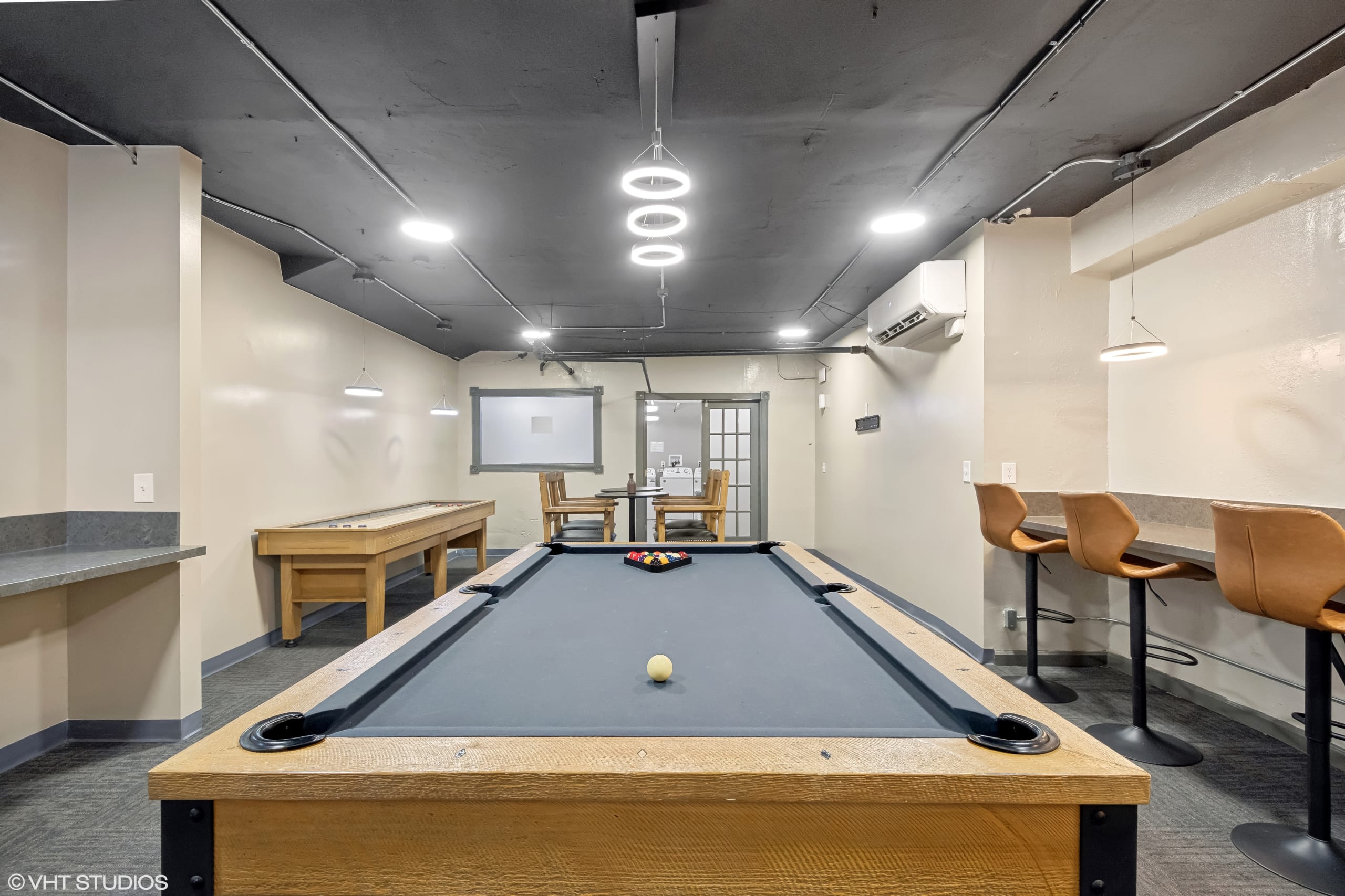 Game room with a pool table and casual seating.